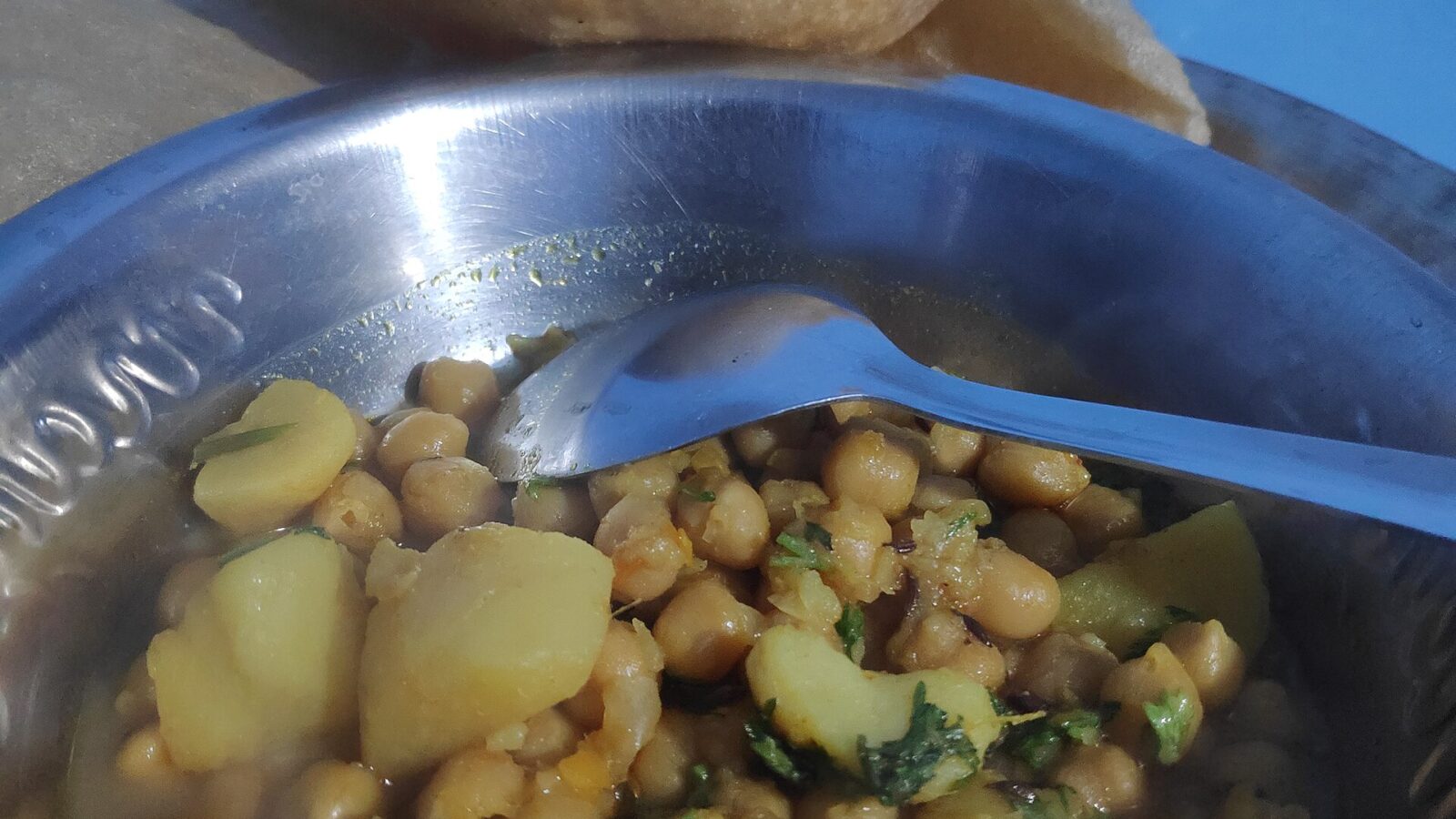 Chickpea curry in a bowl with fried bread